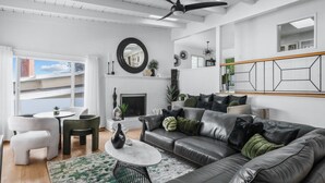 Ein modernes Wohnzimmer mit Kamin, Ledersofa und einem Essbereich mit rundem Tisch.