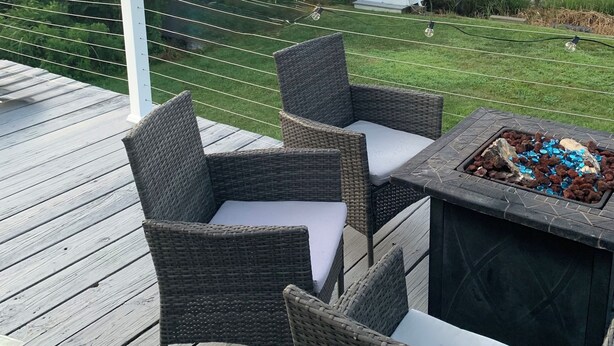 A deck with wicker chairs and a fire pit. - Amazing Water Front 4-bedroom estate in charming Narragansett with AC, WiFi (Narragansett)