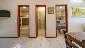 Una habitación con cama, ducha y zona de comedor.