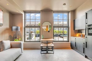 A modern kitchen with large windows, a central island, and a built-in oven. - Kings House (London)