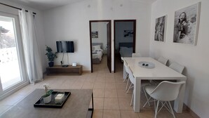 A modern hotel room with a dining area, a TV, a bed, and artwork on the walls. - Charming 3-bedroom apartment with AC, Pool, WiFi in beautiful Biograd na Moru (Biograd na Moru)
