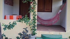 A house with a porch, a hammock, and a staircase leading to the entrance.