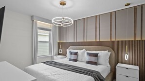 Ein modernes Schlafzimmer mit einem großen Bett, Nachttischen und einem außergewöhnlichen Wandpaneel-Design.