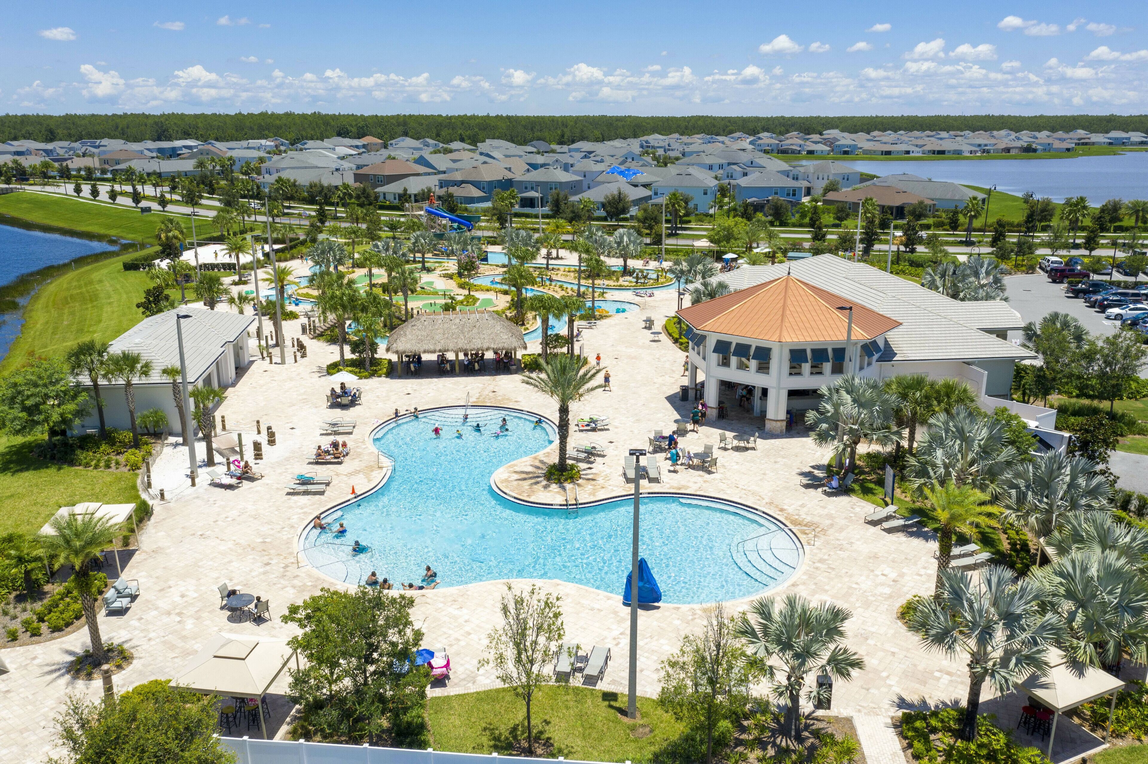 A resort with a large central pool, multiple smaller pools, and a water slide.