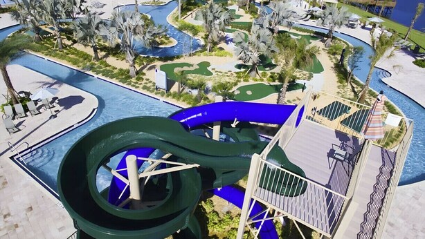 A water park with a large water slide, multiple pools, and a bridge over water. - Last Minute Disney Getaway! Private Pool & Themed Bedrooms. Book Now! #127919 (Orlando)