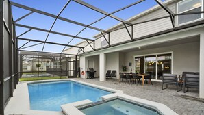 Une piscine avec un patio vitré, un espace salon extérieur et un jacuzzi.