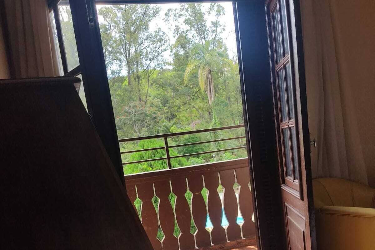 Ein Zimmer mit Balkonblick, einem Bett und einem Sessel.