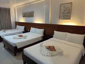 A hotel room with two beds, each with neatly made white linens and brown towels. There are wall-mounted light fixtures and framed botanical artwork above the beds. - Zosimo's Inn (Lazi)