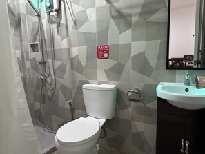 Un baño con inodoro, lavamanos y ducha.