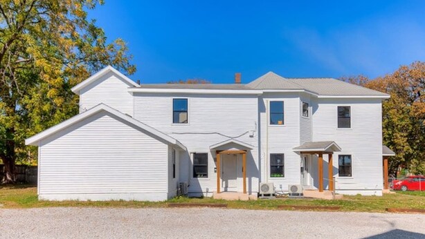 A two-story house with a garage, a covered porch, and a small attached shed. - Near Downtown ~ 2BDR & Fun Backyard ~ Pet Friendly (Des Moines)