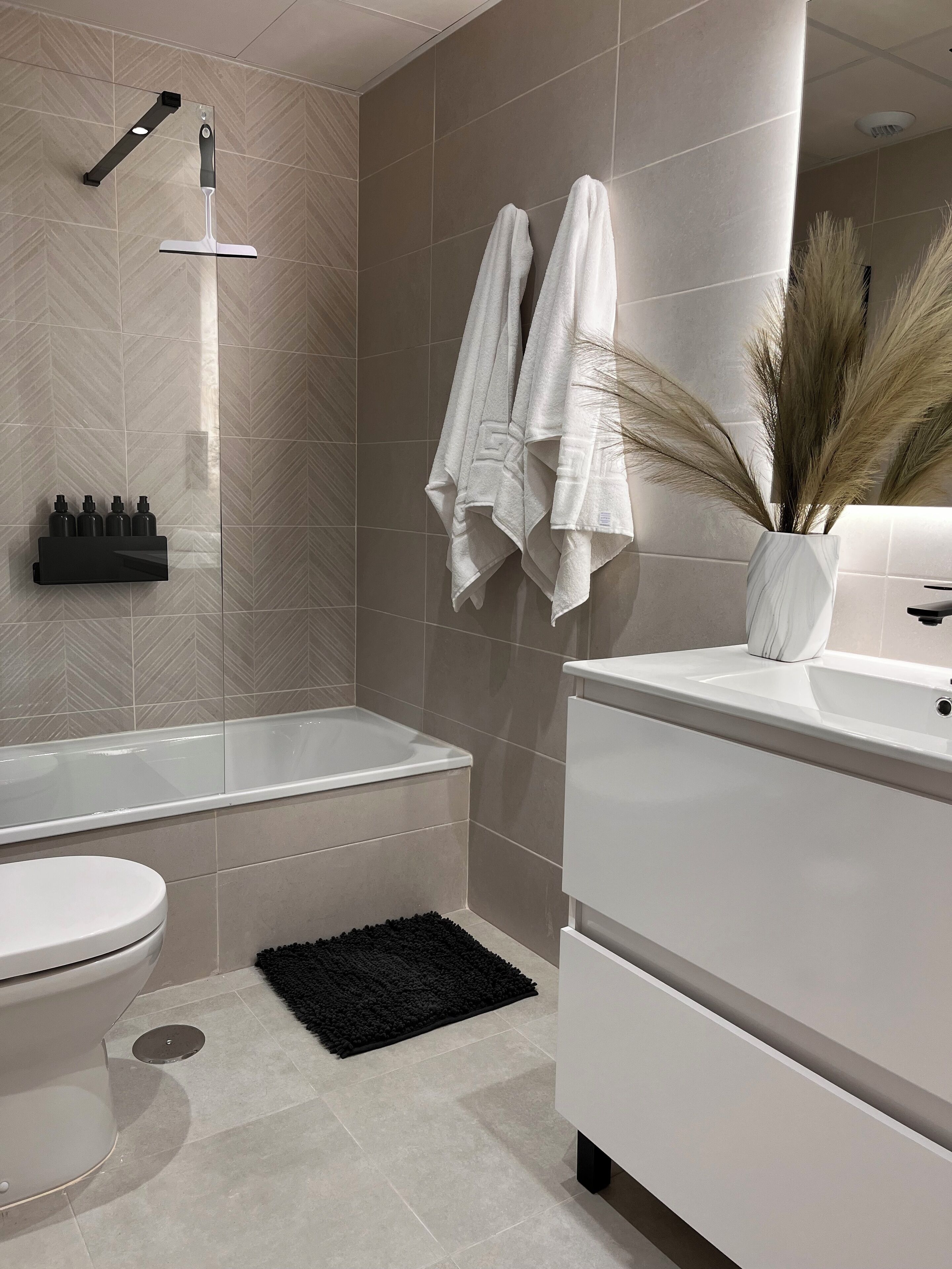 Une salle de bain moderne avec une baignoire, des toilettes et un meuble-lavabo.