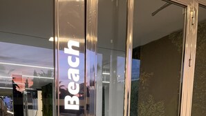 A glass entrance with the sign "Aguacate Beach" indicating the name of the establishment. - Design apartment in Residencial AGUACATE BEACH, golf and beach 5 minutes away.  (AN)