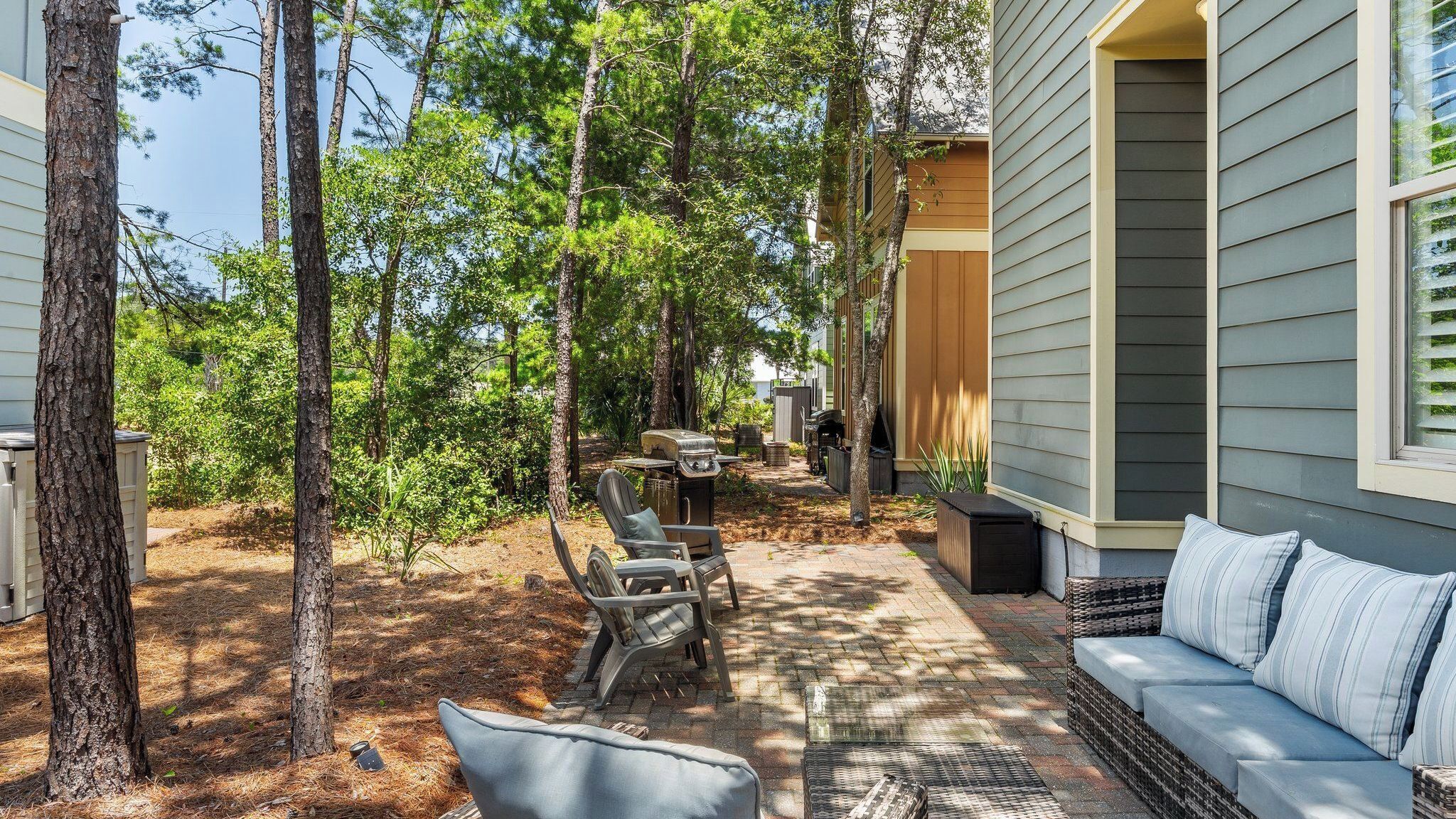 Un patio con mobiliario exterior, una parrilla y un sofá.