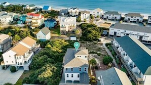 A coastal residential area with houses, some with balconies, and a clear view of the ocean. - This is How We Roll- Shared Pool! (surf City)