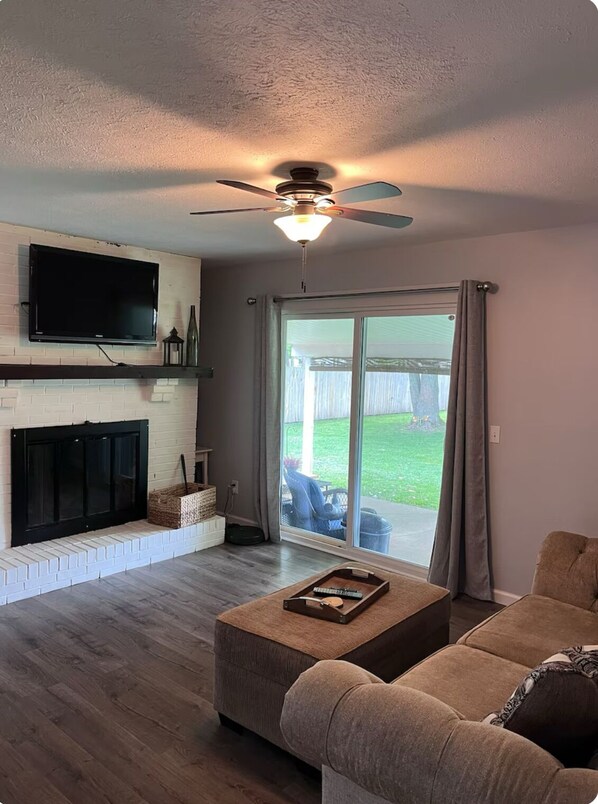 Relax in this cozy living space with a fireplace, flat-screen TV, and sliding glass door to the outdoor area.