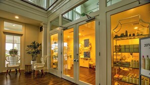 A hotel lobby with a wooden floor, a reception desk, and a glass door entrance. - 4 BR Top Floor Beachfront Condo | Beach Club B2010 (Baldwin County)