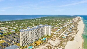 A high-rise hotel with multiple floors, a pool, and a beachside location. - 4 BR Top Floor Beachfront Condo | Beach Club B2010 (Baldwin County)