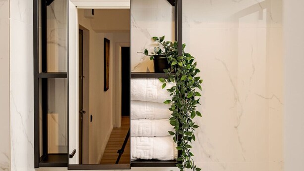 A doorway with a sliding glass door leading to a hallway with a staircase.
