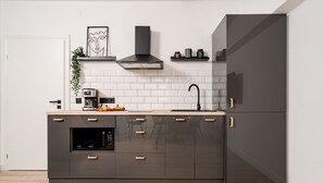 A modern kitchen with a built-in oven, microwave, and a coffee maker on the countertop.