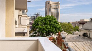 A hotel with a rooftop terrace featuring a large tree and classical architectural elements. - Tyst by MRG Apartments | City Centre Spacious Cozy Apartment with Balcony (București)