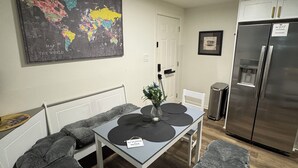 A modern kitchen with a dining area, a world map on the wall, and a stainless steel refrigerator. - Cozy and relaxing apartment with Free WiFi located in vibrant Atlanta. (Atlanta)