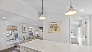 A spacious kitchen with a large island, white cabinetry, and pendant lighting. - Anchor Inn 02 | 1BR/1BA Boca Grande, Chic Comfort (Boca Grande)