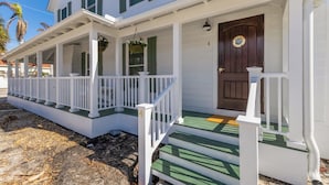 A two-story house with a porch, a front door, and a mailbox.