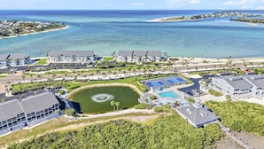 An aerial view of a coastal resort with multiple buildings, a central pool, and a large body of water. - NEW LOW PRICE - Coastal BG North 82, a spacious 2-bed, 2-bath Boca Grande with stunning Gulf views (Boca Grande)