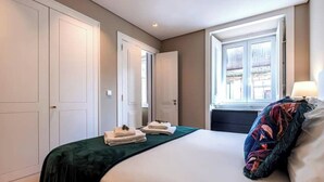 Ein Schlafzimmer mit Bett, Fenster und Tür.