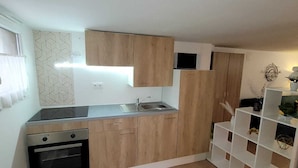 A compact kitchen with wooden cabinets, a built-in oven, and a sink.