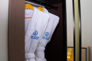 Um armário com toalhas brancas penduradas em um suporte, cada uma com um logotipo e texto indicando que pertencem a um hotel e restaurante.