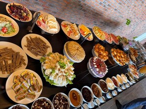 A buffet table with various food items and condiments. - Port Marine Hotel (Baku)