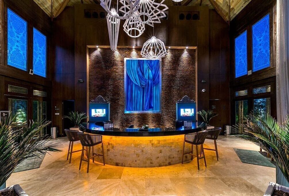 A reception area with a curved counter, two televisions, and a large blue curtain backdrop.