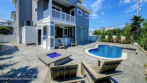 A two-story house with a backyard featuring a swimming pool, a hot tub, and outdoor seating. - Immaculate Pool/Elevator 5 bedroom, 4 bath home w/outdoor living space/fire pit  (Harvey Cedars)