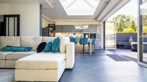 Ein modernes Wohnzimmer mit einer Couch, einem Essbereich und einer Küche.