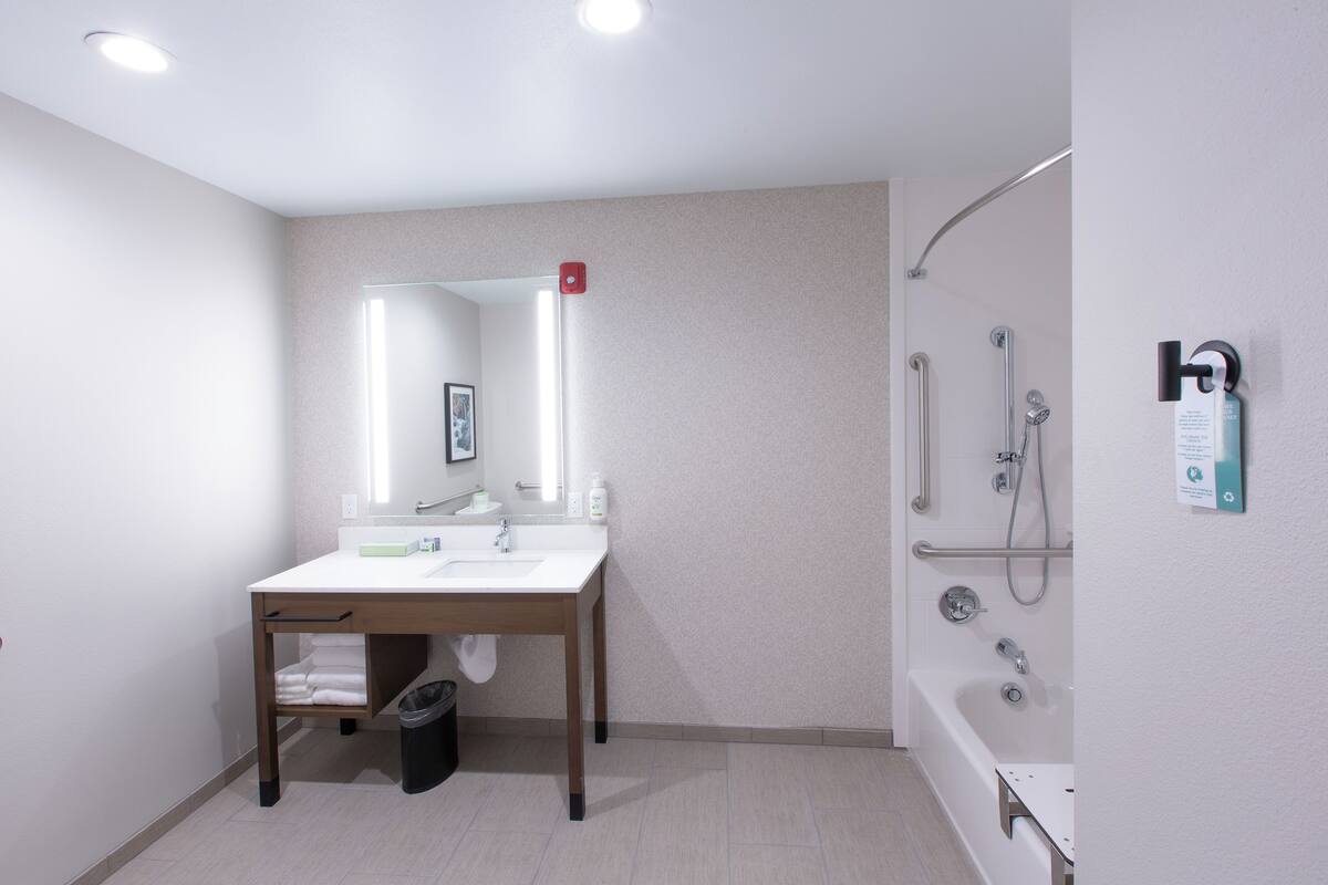 Une salle de bain moderne avec un lavabo, un miroir et une douche.