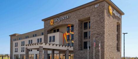 Un hotel con fachada de piedra y un llamativo letrero de 'La Quinta', además de numerosas ventanas.