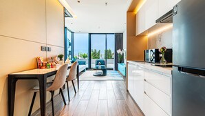 A modern kitchen with a dining area, large windows, and a view of the outdoors. - Beverly Mountain Bay, Trademark Collection By Wyndham (Pattaya)