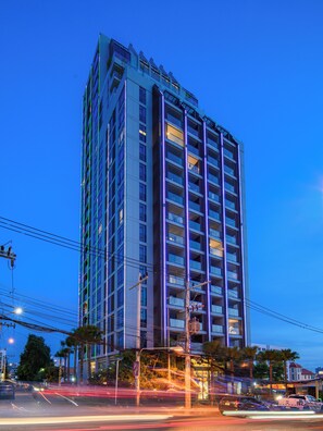 Un edificio de gran altura con varios pisos, balcones y un diseño arquitectónico moderno.