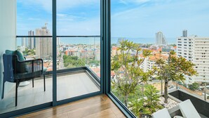 Un balcone con vista sulla città, una sedia e un piccolo gruppo di piante.