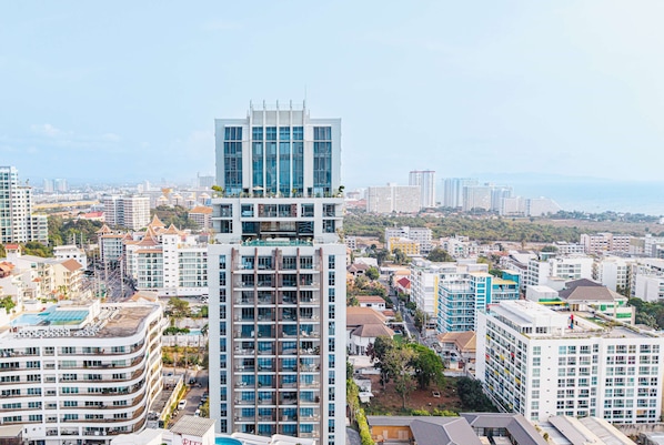 A high-rise building with multiple floors, large windows, and a modern architectural design. - Beverly Mountain Bay, Trademark Collection By Wyndham (Pattaya)