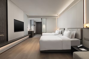 Habitació d'hotel moderna amb dos llits, televisió de pantalla plana, taules de nit i un gran mirall.
