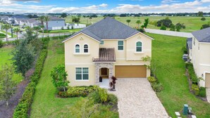 A two-story house with a stone archway entrance, a garage, and a well-maintained lawn. - Sleeps 20! 9bdr, Star Wars-themed Game Room, Pool, Hot Tub Nassau by Avantstay (Kissimmee)