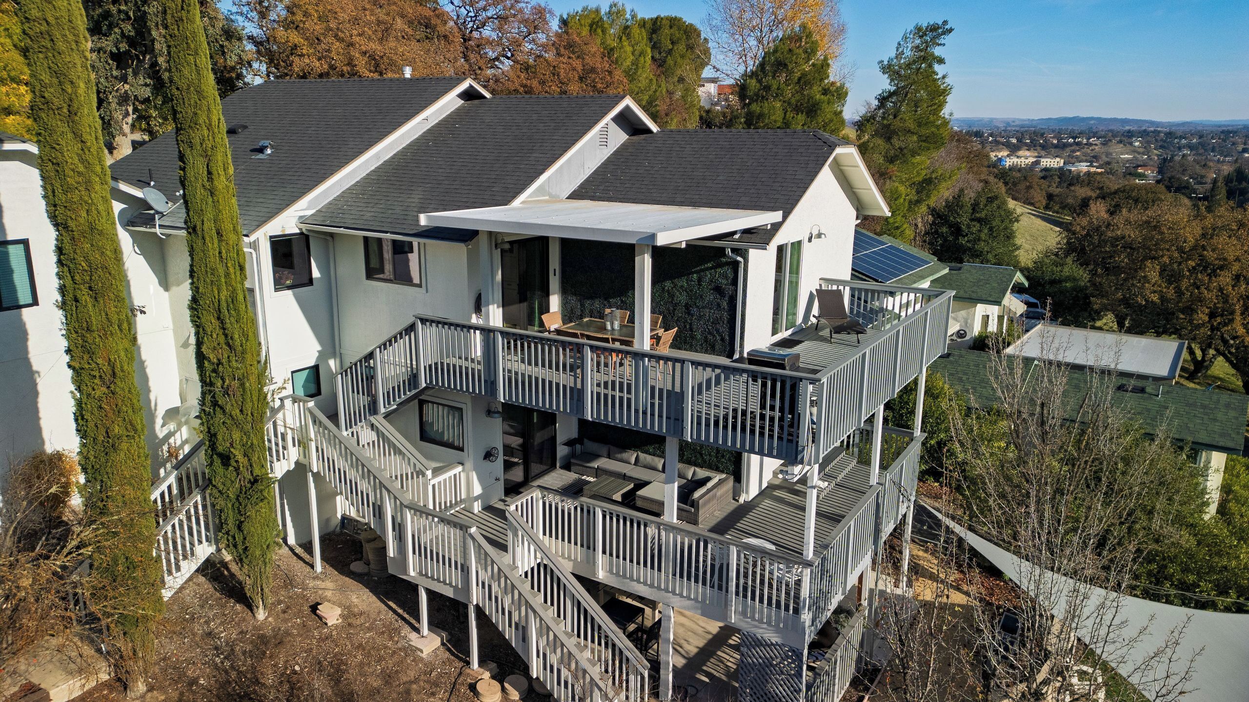 Une maison à plusieurs étages dotée d’un balcon, d’un espace extérieur aménagé pour s’asseoir et offrant une vue sur les environs.