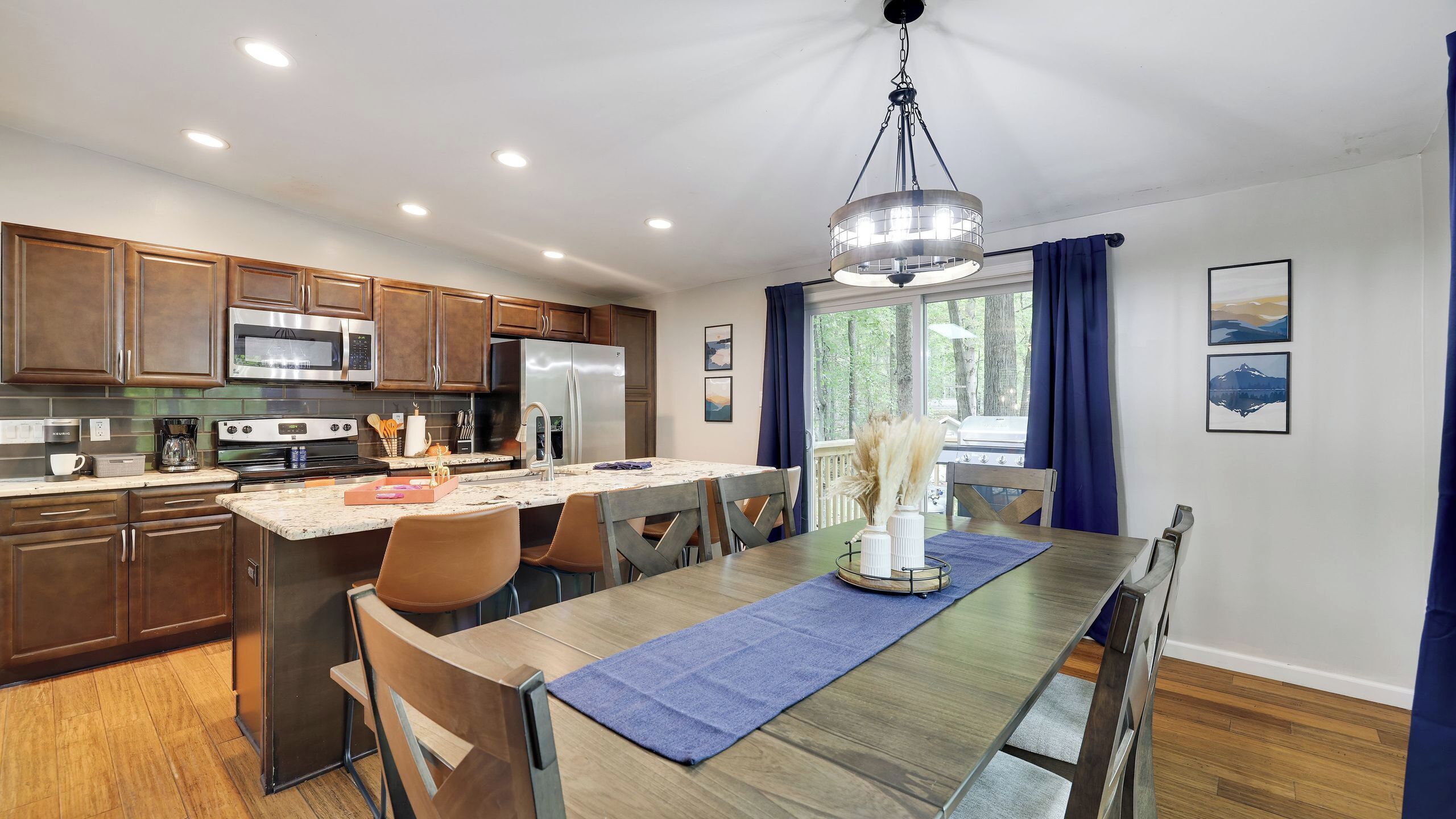 A modern kitchen with dark wood cabinets, stainless steel appliances, and a large island with seating.