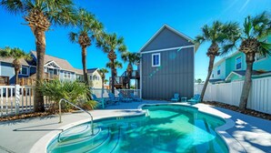 A swimming pool surrounded by palm trees and houses. - Communal Pool, Beach Gear & Prime Location Near Port Aransas Beaches Salty Seas by Avantstay (Port Aransas)