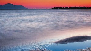 A calm body of water with a mountain range in the background and a clear sky. - Apartments Galić - 1 Bedroom with Lake view (Ploce)