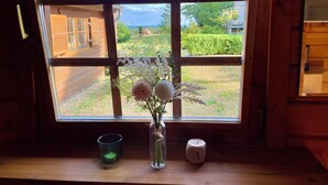 A window with a view of a wooden house and a garden. - Almhuetten-am-Meer.de (Lubmin)