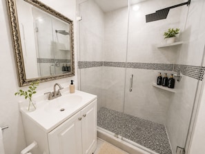A bathroom with a white sink, mirror, and shower. - Miami 2BR Home • Jackson Hospital - Parking (Miami)