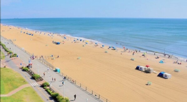 Relax on the beach with comfortable seating and umbrellas, steps from the ocean.